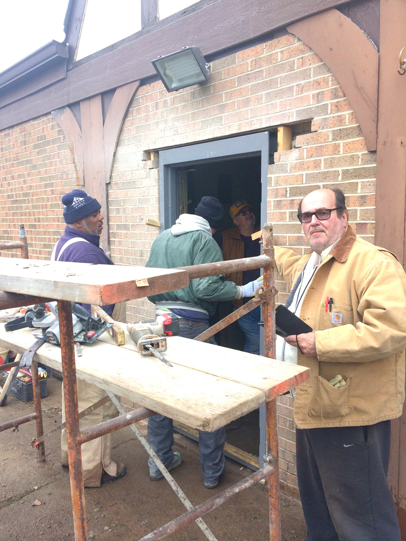 People working together outside a brick building