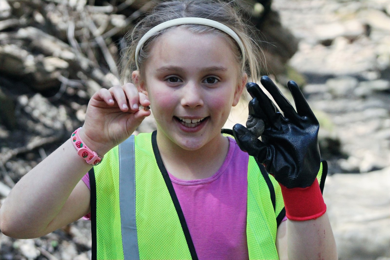 Young volunteer wearing a safety vest and gloves during a community cleanup